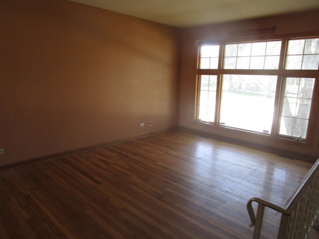 75 Tweed Road Fox Lake, IL 60020 - Photo 7 of 17 a view of an empty room with wooden floor and a window