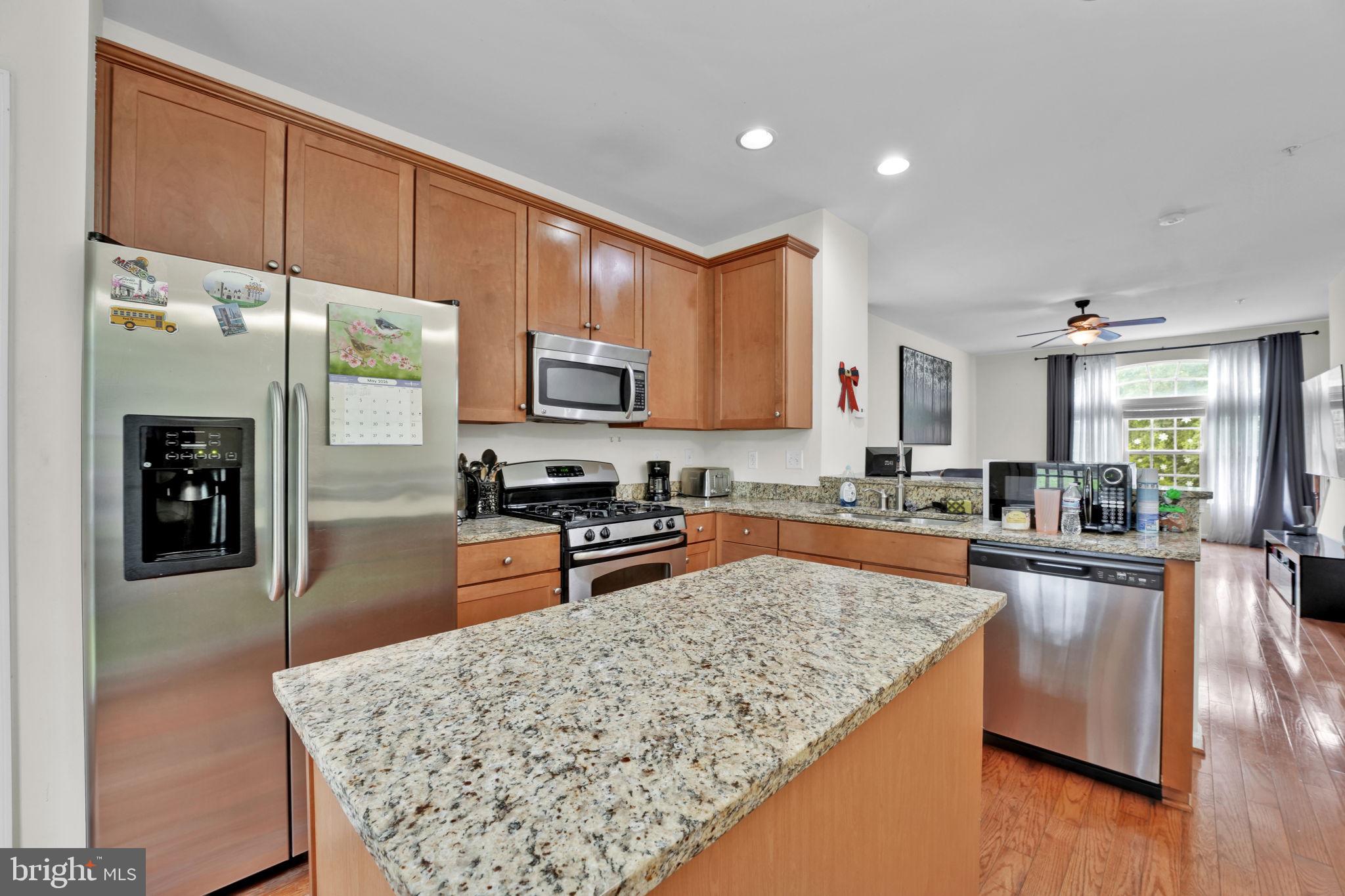7138 Station House Road Elkridge, MD 21075 - Photo 26 of 42 a kitchen with stainless steel appliances granite countertop a stove refrigerator sink and cabinets