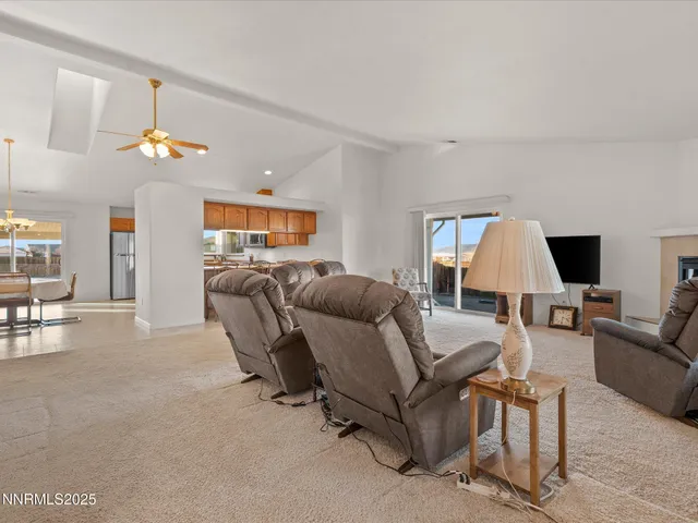 a living room with furniture flat screen tv and a large window