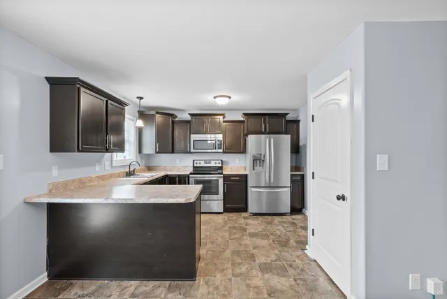 a kitchen with stainless steel appliances granite countertop a sink stove and microwave