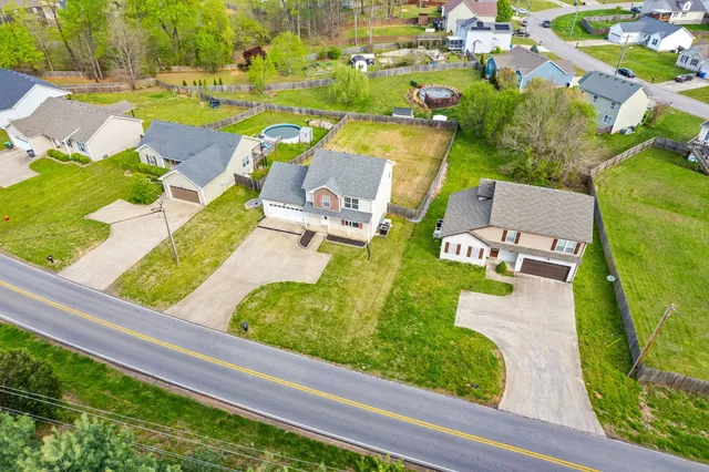an aerial view of a swimming pool with a yard