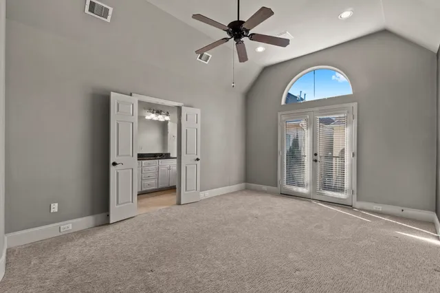 an empty room that has a window and a ceiling fan