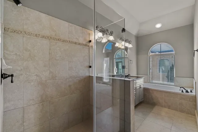 a large bathroom with a granite countertop sink a large mirror and a shower