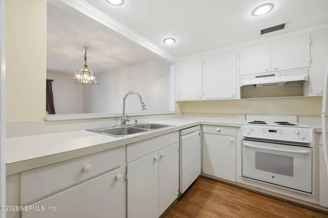 a kitchen with a sink stove and cabinets