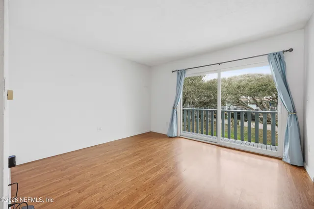 a view of a big room with wooden floor and windows