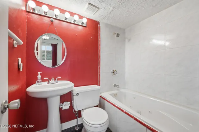 a bathroom with a sink mirror toilet and bathtub