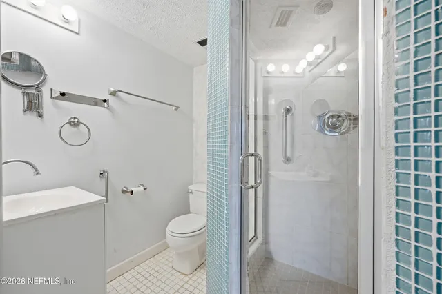a bathroom with a shower a sink and toilet