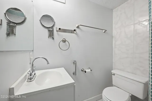 a bathroom with a sink toilet and mirror