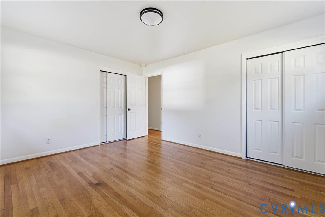 6413 Bull Hill Road Prince George, VA 23875 - Photo 20 of 27 Unfurnished bedroom featuring two closets and wood