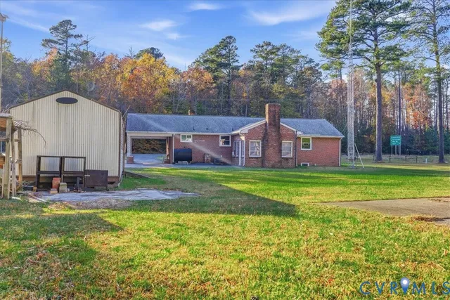 a front view of house with yard and trees in the background