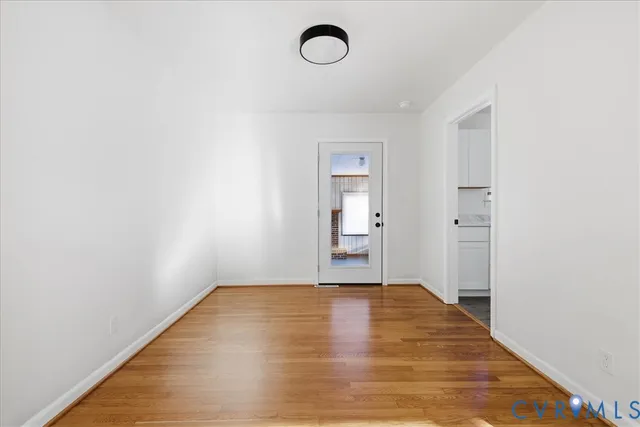 a view of a room with wooden floor and window