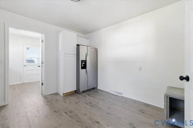 a view of a livingroom with wooden floor and a fireplace