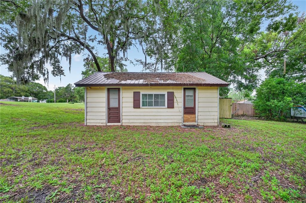 5514 Southeast Hames Road Belleview, FL 34420 - Photo 29 of 44 a backyard of a house with plants and large tree