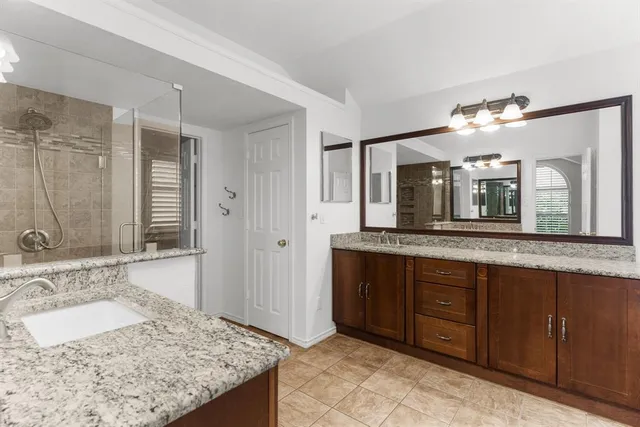 a bathroom with a granite countertop sink and a large mirror