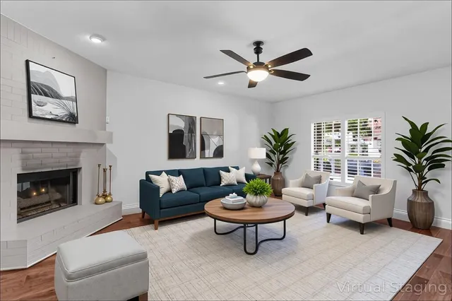 a living room with furniture a fireplace and a potted plant