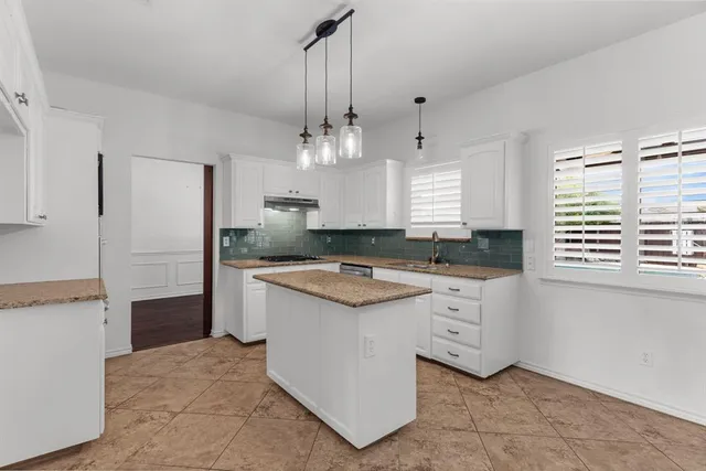 a kitchen with granite countertop a sink stove and refrigerator