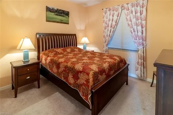 a bed sitting in a bedroom next to a lamp