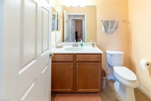 a bathroom with a granite countertop toilet sink and mirror
