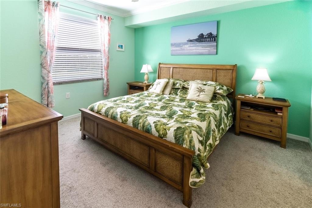 9723 Acqua Court, Unit 334 Naples, FL 34113 - Photo 17 of 49 a bed sitting in a bedroom next to a window