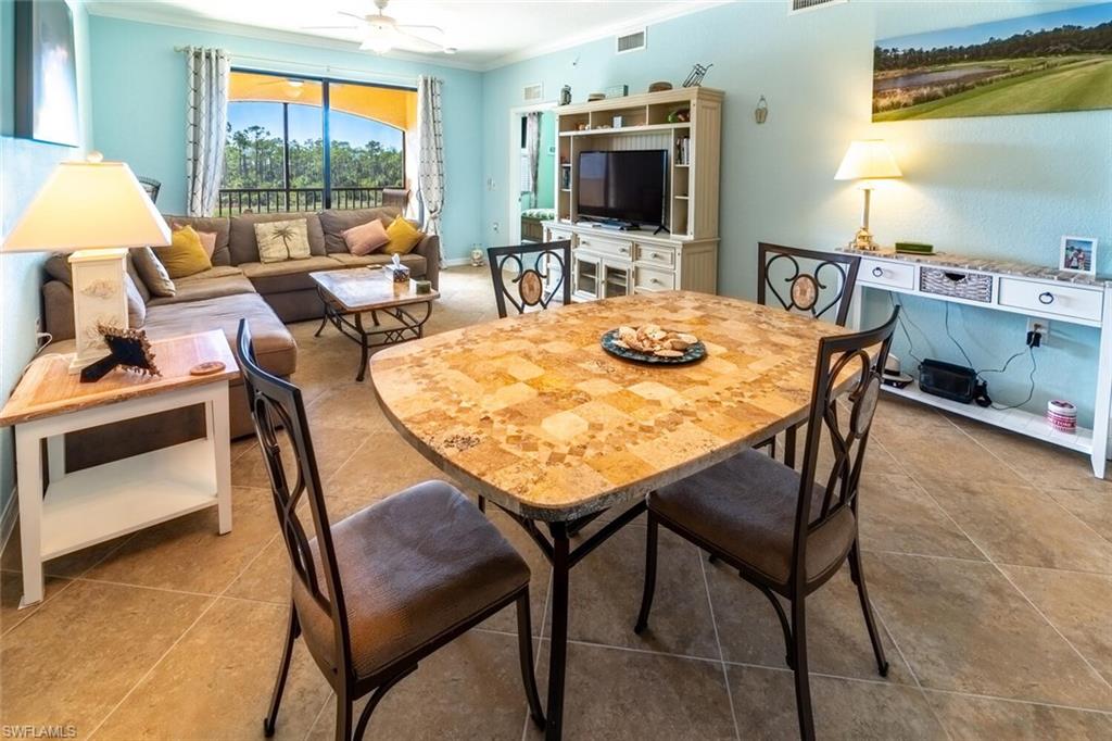 9723 Acqua Court, Unit 334 Naples, FL 34113 - Photo 8 of 49 a view of a dining room with furniture and a flat screen tv