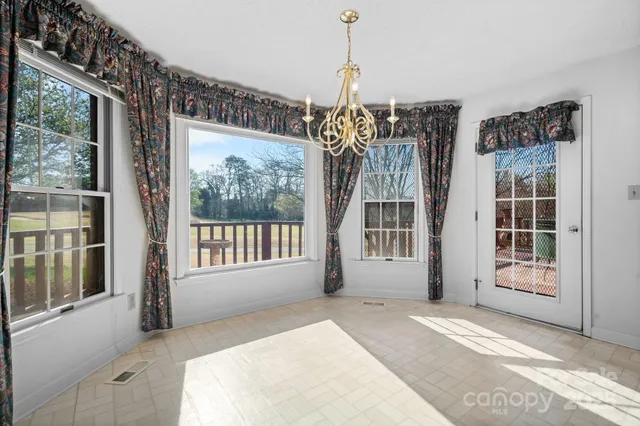 a view of an empty room with windows and closet