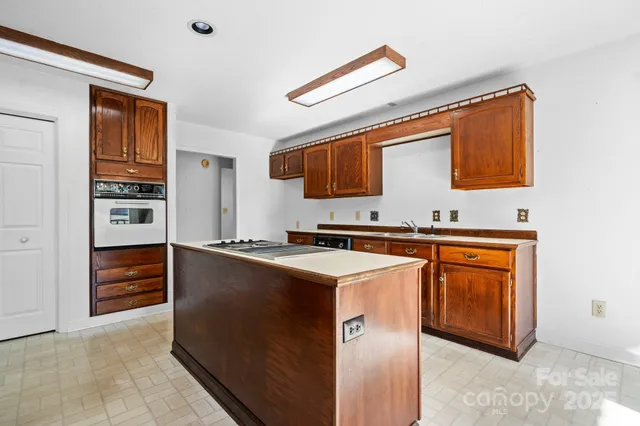 a kitchen with stainless steel appliances granite countertop a sink a stove and a refrigerator