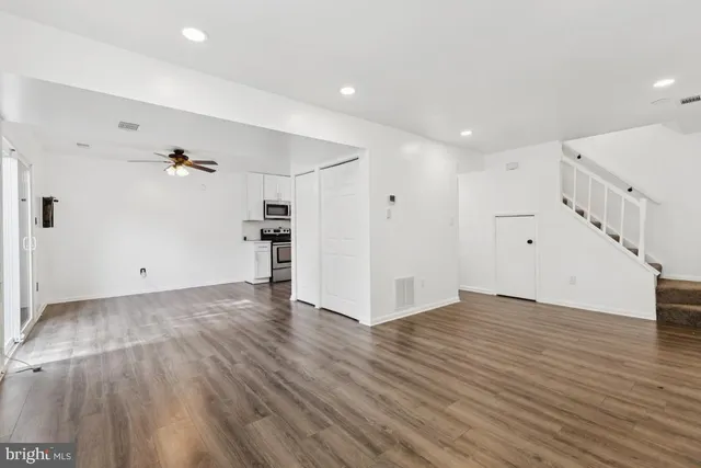 a view of empty room with wooden floor