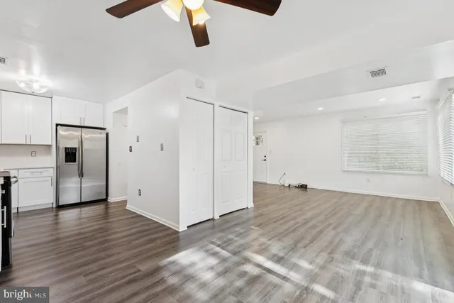 a view of empty room with wooden floor and window