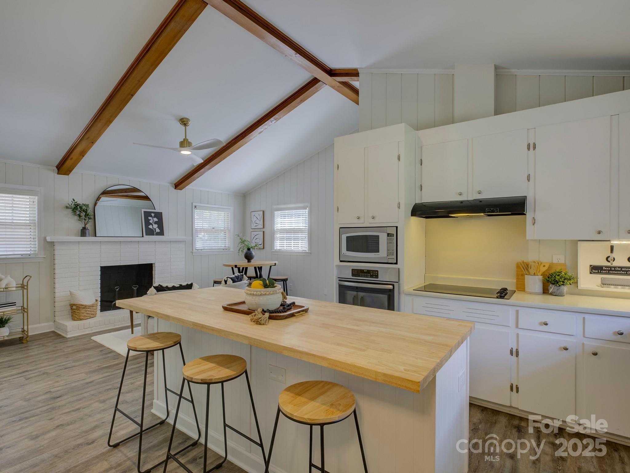 5601 Londonderry Road Charlotte, NC 28210 - Photo 15 of 42 a kitchen with stainless steel appliances kitchen island granite countertop a table chairs sink and cabinets