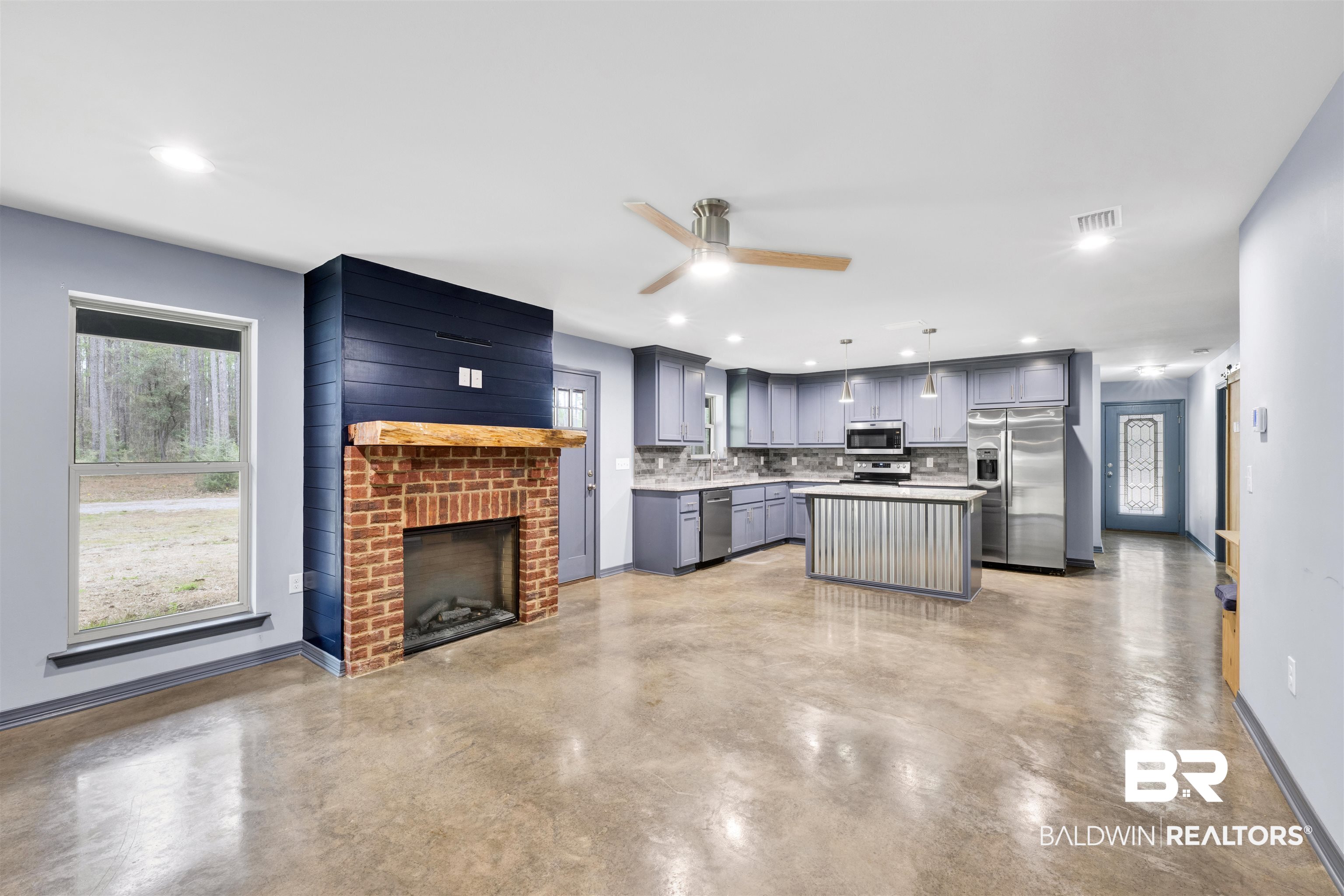 36397 Alexandria Trail Stapleton, AL 36578 - Photo 62 of 65 Kitchen featuring open floor plan, a center island, concrete floors, stainless steel appliances, and a brick fireplace