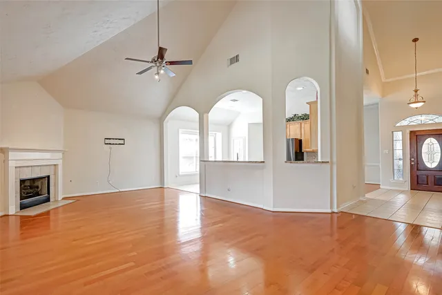a view of empty room with fireplace and wooden floor