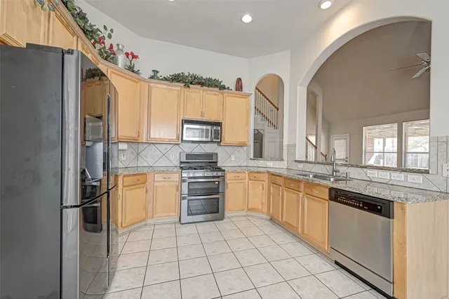 a kitchen with stainless steel appliances granite countertop a refrigerator and a sink