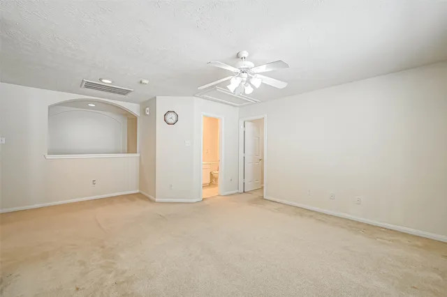 an empty room with a bathroom and a window