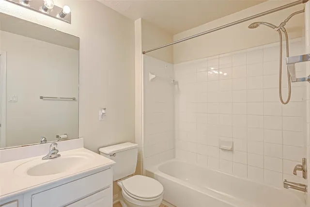 a bathroom with a bathtub shower sink vanity and toilet