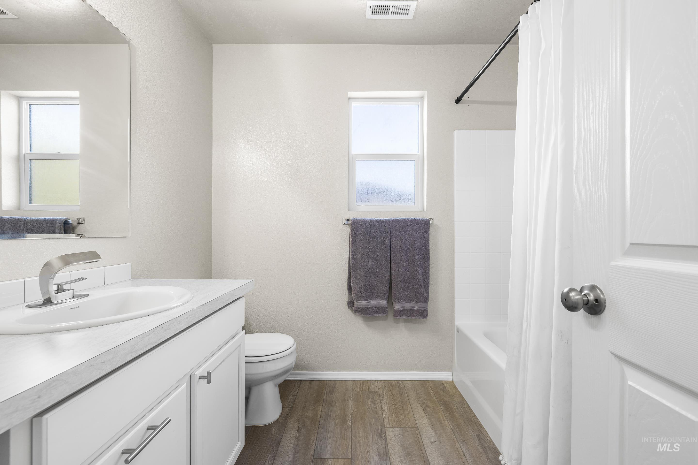20202 Jennings Way Caldwell, ID 83605 - Photo 23 of 30 Full bath featuring dark wood-type flooring, vanity, and shower / bathtub combination with curtain