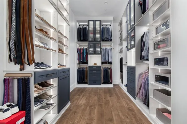 a view of walk in closet with clothes and shoes