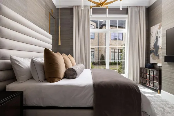 a bedroom with a bed lamp and a large window