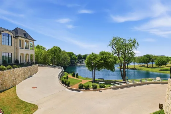 a view of a swimming pool with a yard and large tree