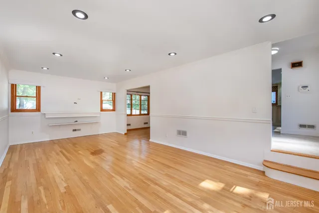 a big room with wooden floor and windows