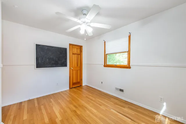 an empty room with a window and a ceiling fan