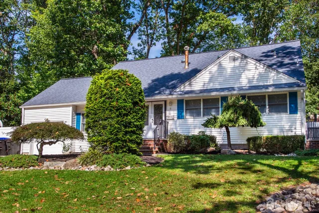 a view of house with garden and tall trees