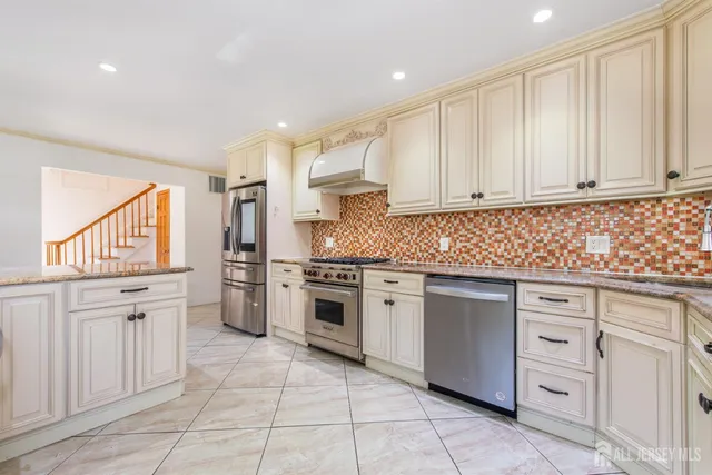 a kitchen with cabinets appliances and a window