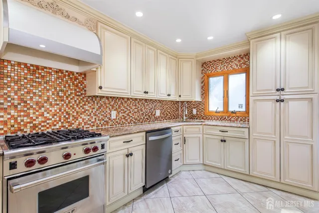 a kitchen with granite countertop white cabinets and stainless steel appliances