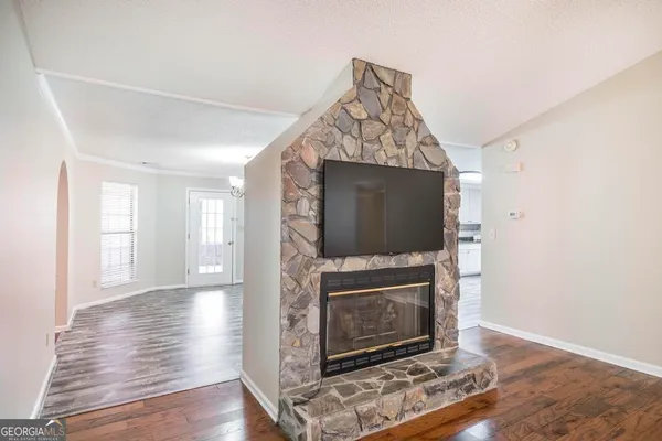 a kitchen with a sink dishwasher a stove and white cabinets with wooden floor