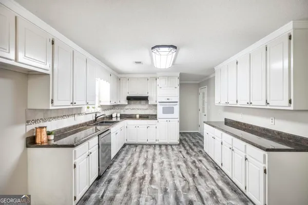 a kitchen with a stove and a white cabinets