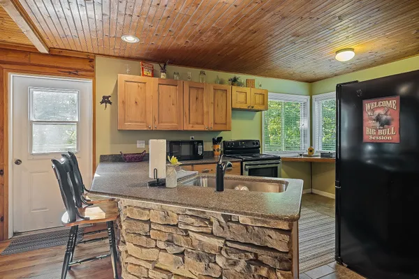 a kitchen with a stove a sink and wooden cabinets