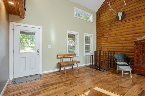 a living room with furniture a flat screen tv and floor to ceiling windows