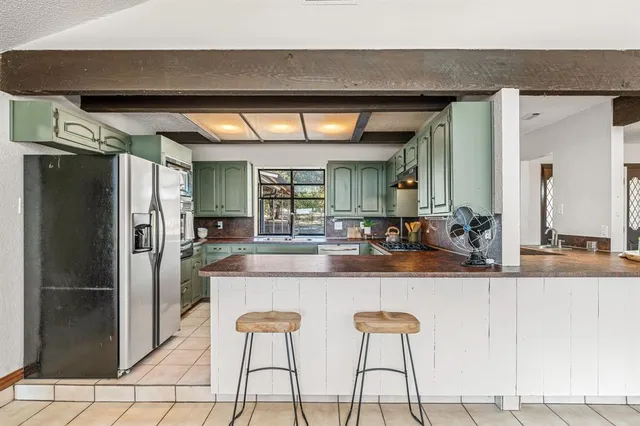 a kitchen with kitchen island a sink a stove and cabinets