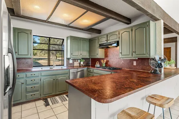 a kitchen with stainless steel appliances granite countertop a stove sink and microwave