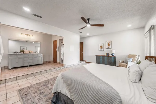 a spacious bathroom with double sink shower and mirror